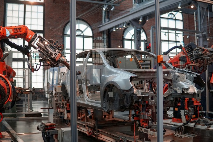 gray vehicle being fixed inside factory using robot machines